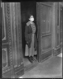 Elevator girl in flu mask, 1918, University of Washington, Wikimedia. 